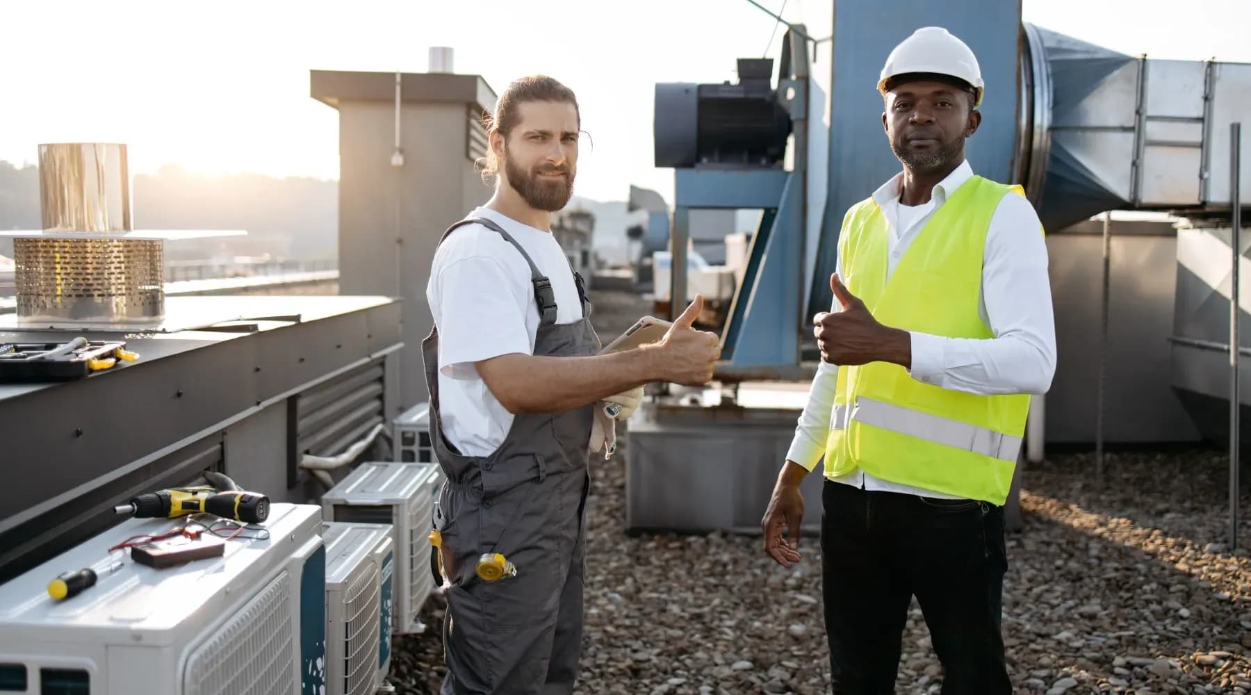 Dos especialistas que están sobre techo de un edificio discutiendo sobre el funcionamiento de los chillers para ventilación.